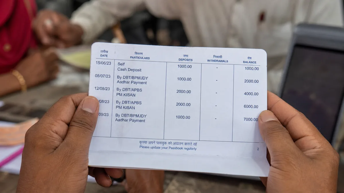 Passbook में DBT की entry दिखाते हाथ