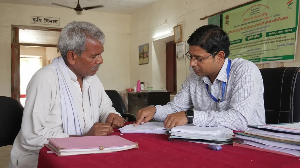 किसान कृषि अधिकारी को अपने कागज दिखाते हुए
